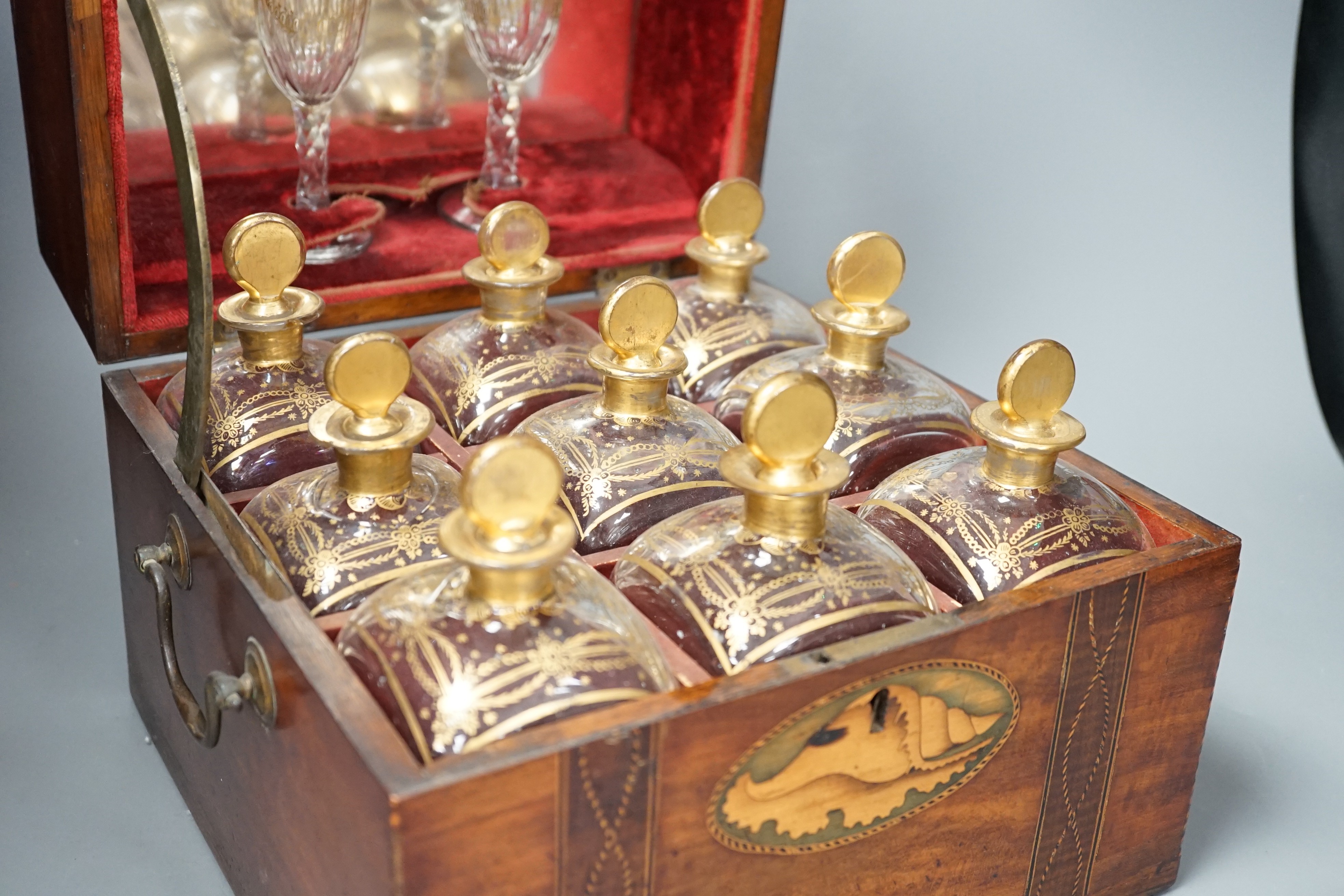 A 19th century Dutch inlaid mahogany decanter box containing nine gilt glass decanters and two glasses, 27cm